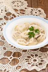 Dumplings in plate on wooden background. Vertical. Russian or Ukrainian national food