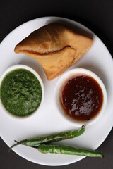 Indian snack Homemade spicy and delicious samosa served with green, tamarind chutney.