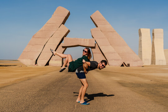 Couple jump near huge Gate of Allah, Ras Mohammed national park in Egypt. Desert