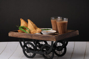 Indian snack Homemade spicy and delicious samosa served with green, tamarind chutney cutting masala...