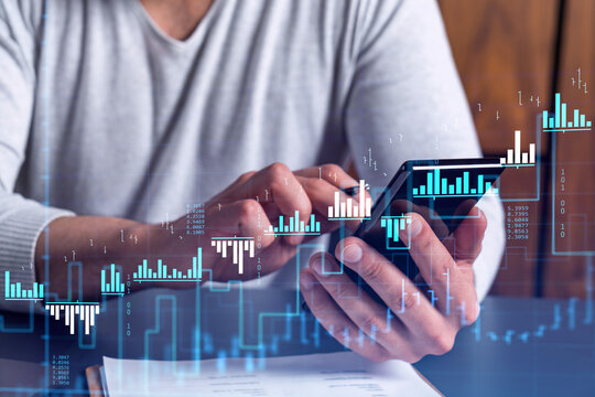 Trader holding in the hands a smart phone and researching stock market to proceed right investment solutions. Internet trading and wealth management concept. Hologram Forex chart over close up shot.