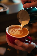 Fototapeta na wymiar hand holding a cup of coffee and a latte art