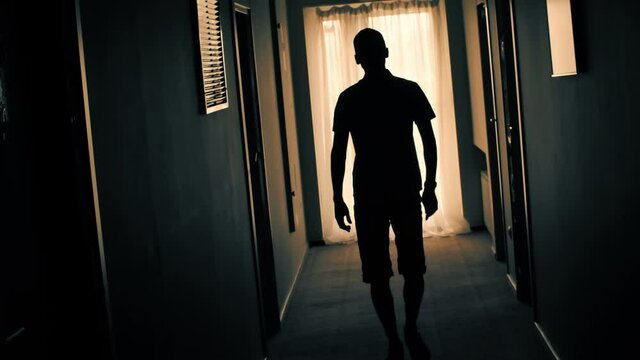 Silhouette of a man walking down the hallway