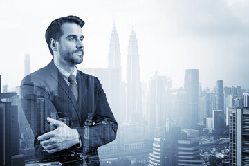 Prosperous European entrepreneur in suit in crossed arms pose. Kuala Lumpur cityscape. The concept of problem solving. KL skyscrapers. Double exposure.