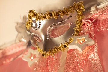 Gold and grey carnaval mask and rose curtains decorate girl's bed
