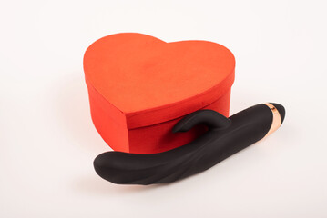 Black dildo and heart shaped box on a white background. Valentine's day gift.
