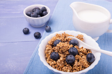 on lavender blue table, healthy breakfast with crunchy wholemeal muesli of barley and oats,...