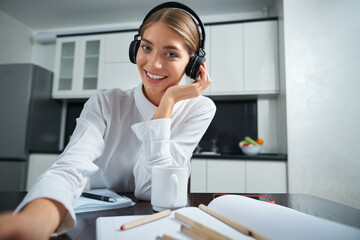 Attractive woman wearing headphones during video call