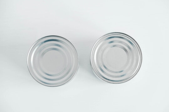 Two aluminum closed metal cans on a white table. Top view. Copy, empty space for text