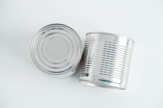 Two aluminum closed metal cans on a white table. Top view. Copy, empty space for text