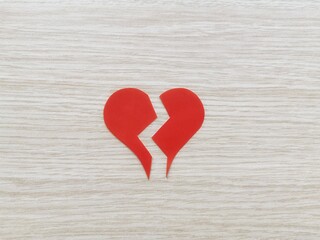 Two half hearts. Broken hearts. Hearts that will come together. Red heart. Valentine's Day. Wooden floor and broken heart.