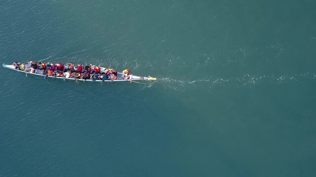 Dragon Boat team rowing together. Teamwork on Dragon Boat at sea. 