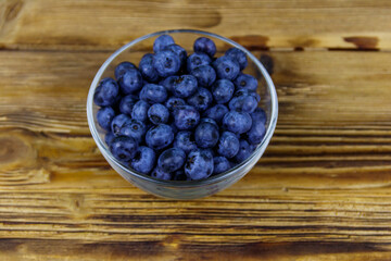 Fresh blueberry in glass bowl on a wooden table