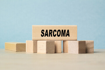 the word SARCOMA is written on a wooden cubes structure . Cube on a bright background. Can be used for Medical concept. the medicine.