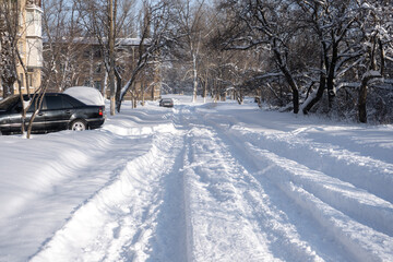 Small city covered with snow. Little buildings and houses on winter with a lot of snow drifts on a street.