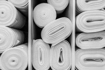 Industrial white foam rolls or thermal insulation materials in a hardware store. Laminate and...