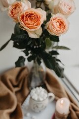 Morning cup of coffee, white notebook, roses in a vase. Beautiful breakfast. Flat lay style.