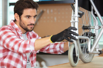 man maintaining a wheelchair raised on a bench