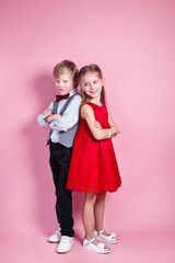 Valentine's Day concept..Cute smiling boy and girl standing on a pink background .