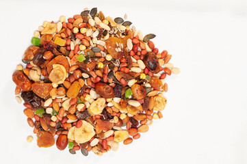 On a light background, various dried fruits - bananas, raisins, apricots, dates and nuts, sunflower seeds and pumpkin seeds