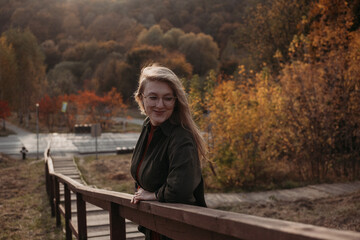 Fototapeta premium Young beautiful woman having a walk outdoors on golden our autumn. Lifestyle concept