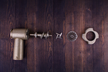 disassembled meat grinder on wooden table