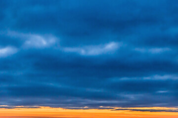 Dark blue rain clouds and skyline sunset background, soft focus