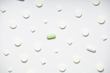 One colored pill on a background of white pills