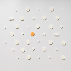 One colored pill on a background of white pills