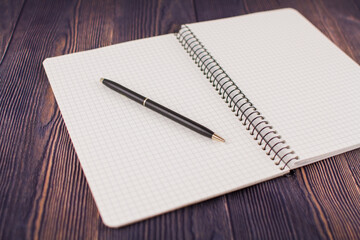 notebook with pen on a wooden table