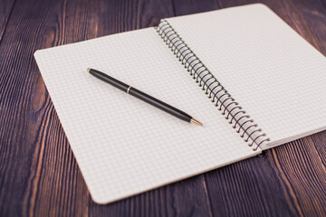 notebook with pen on a wooden table