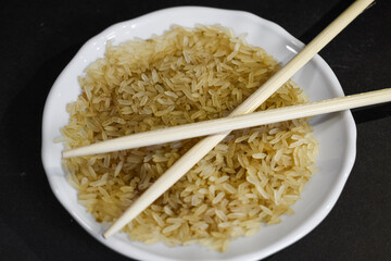 Arroz integral en un plato con palillos chinos