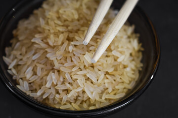 Arroz integral en un recipiente de vidrio con palillos chinos