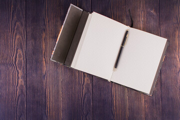 notebook with pen on a wooden table