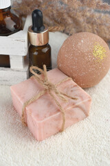 Spa aroma set with soap bar, bath bombs and essential oil bottle on towel. Health care and beauty.  Natural homemade cosmetic. Wellness. Trendy still life composition.
