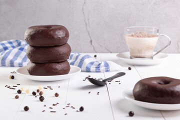 Stack of chocolate donuts on light background.