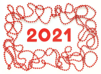 Red felt numbers 2021 on white background. Red beads around. Flat lay for Valentine's Day or New Year. Review of the last year.