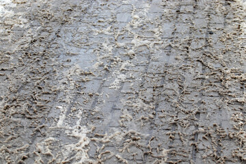 Slush and dirt on the sidewalk in winter. Slippery sidewalk uncleaned of snow.