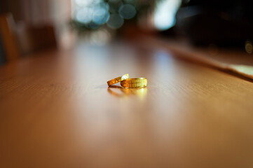 Dos anillos de compromiso encima de una mesa con poca profundidad de campo.