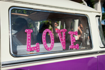 La palabra amor en inglés escrita en el cristal de una furgoneta rosa