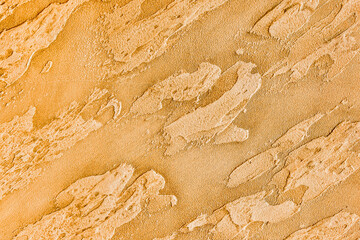 Yellow stucco with abstract pattern texture, gold plaster wall background