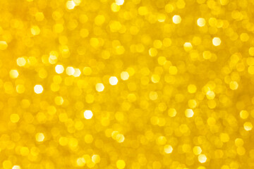 Abstract golden yellow blurred glitter background. Circle defocused lights bokeh. Color of the year 2021 Illuminating Yellow