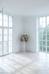 chic white huge spacious hall with a minimum of expensive antique furniture. Baroque interior design with ornament on the walls and parquet on the floor.