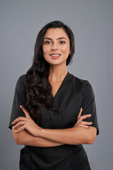Attractive female beautician in black uniform in studio