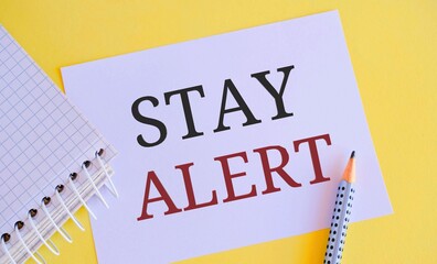 Stay alert text writen on white paper. Concept meaning Paying full attention to things around Quick to see or understand