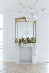 Fototapeta premium chic white huge spacious hall with a minimum of expensive antique furniture. Baroque interior design with ornament on the walls and parquet on the floor.
