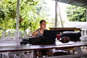 Digital nomad man working in a cabin in the jungle