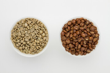 Specialty green and roasted coffee beans from Kenya on a white background. Top view