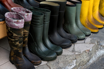 Colored gumboots on the street market different stiles