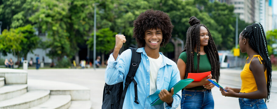 Cheering afro american male student with group of young adults